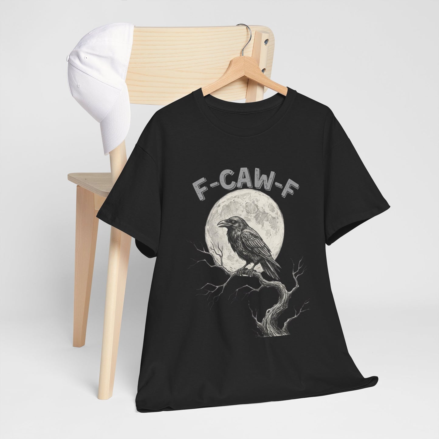 Black t-shirt with a graphic design of a crow and moon on a hanger against a white background